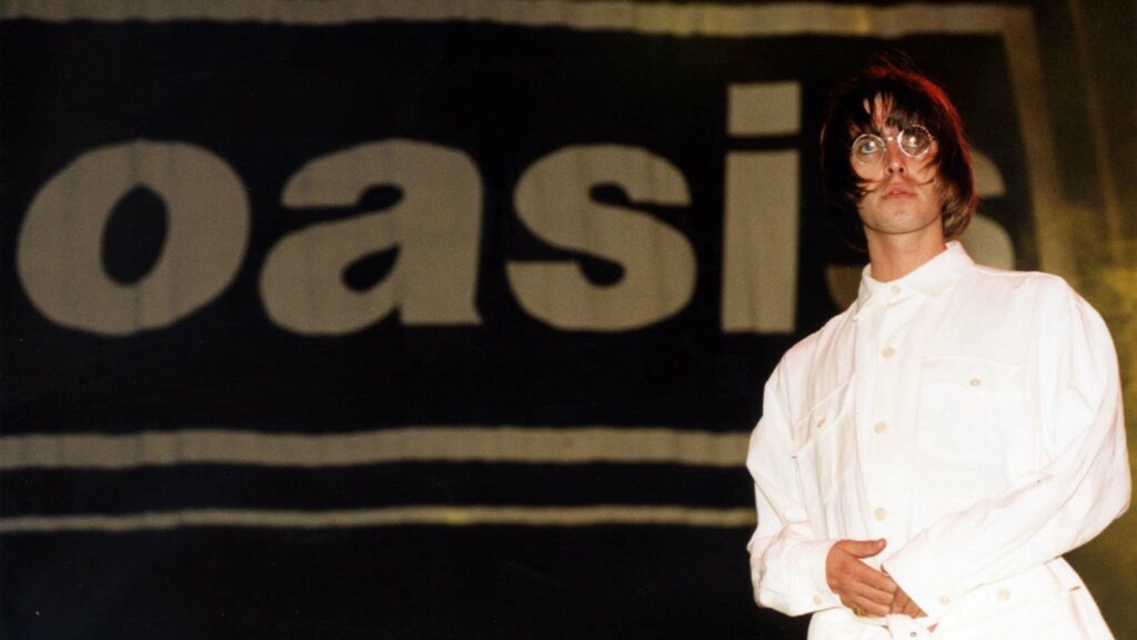 Liam Gallagher on stage during the Knebworth Park Oasis concert on August 10, 1996. Photo: Stefan Rousseau. Copyright: PA Archive/PA Images.