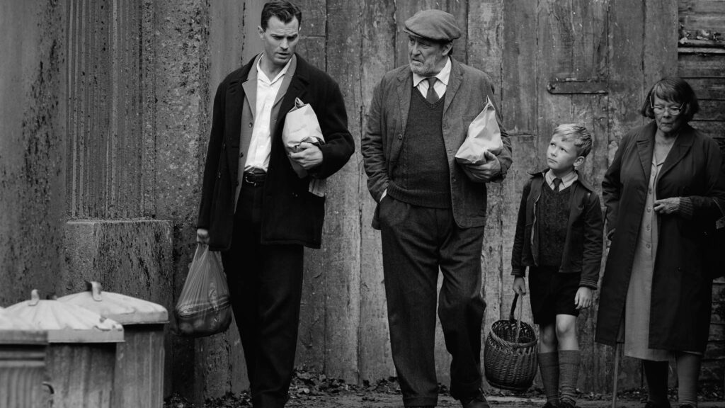 Jamie Dornan as Pa, Ciaran Hinds as Pop, Jude Hill as Buddy and Judi Dench as Granny in Belfast, directed by Kenneth Branagh. Photo: Rob Youngson. Copyright: 2021 Focus Features, LLC. All Rights Reserved.