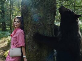 Keri Russell as Sari and the bear in Cocaine Bear, directed by Elizabeth Banks. Photo: Pat Redmond. Copyright: Universal Pictures. All Rights Reserved.