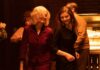 Anne Hathaway as Dr Rebecca St John and Thomas McKenzie as Eileen Dunlop in Eileen, directed by William Oldroyd. Photo: Jeong Park. Copyright: Universal Pictures. All Rights Reserved.