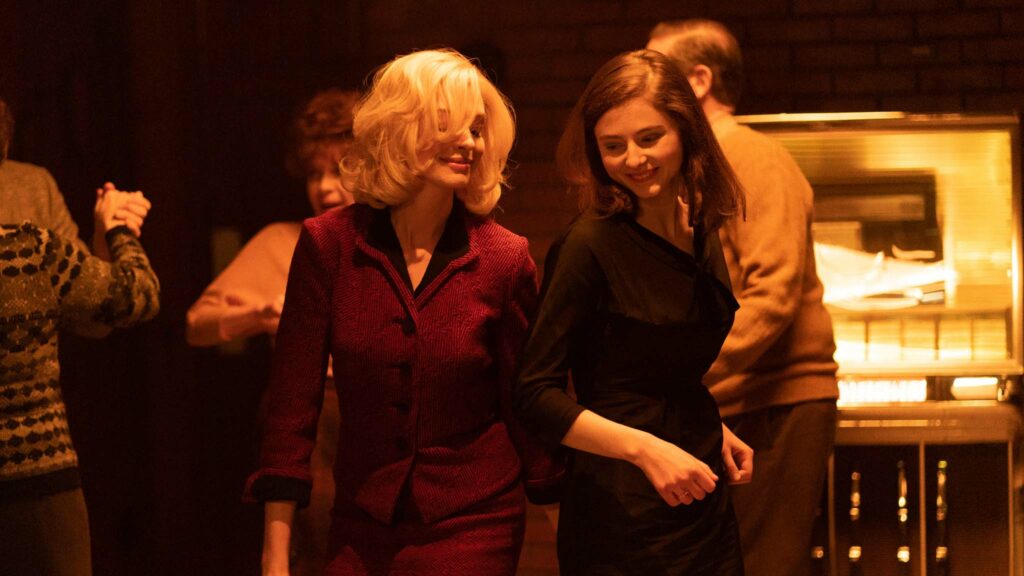 Anne Hathaway as Dr Rebecca St John and Thomas McKenzie as Eileen Dunlop in Eileen, directed by William Oldroyd. Photo: Jeong Park. Copyright: Universal Pictures. All Rights Reserved.