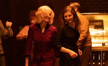 Anne Hathaway as Dr Rebecca St John and Thomas McKenzie as Eileen Dunlop in Eileen, directed by William Oldroyd. Photo: Jeong Park. Copyright: Universal Pictures. All Rights Reserved.