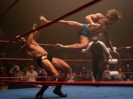 Zac Efron as Kevin Von Erich performing a flying kick in the ring in The Iron Claw, directed by Sean Durkin. Copyright: House Claw LLC. All Rights Reserved.