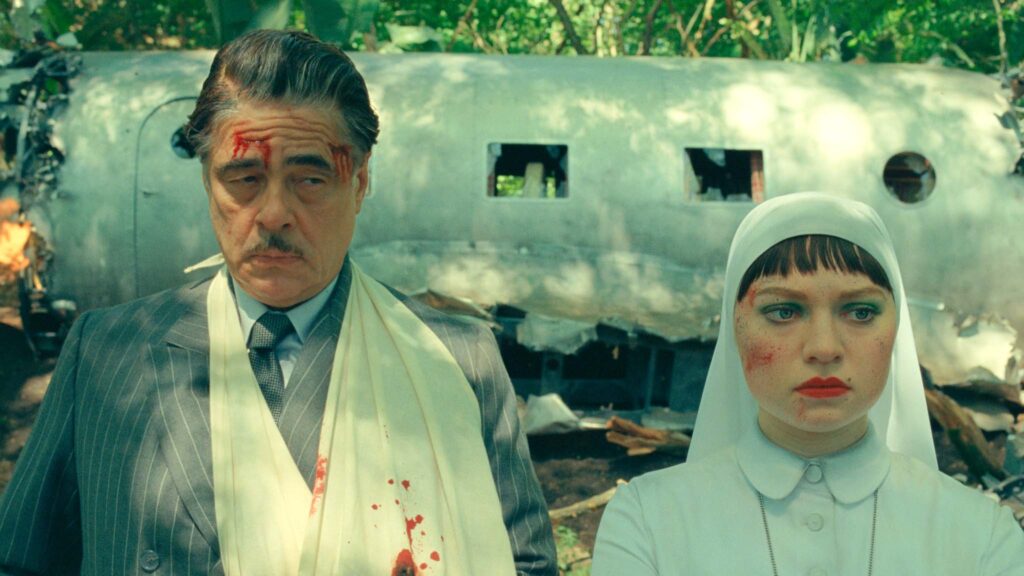 Benicio Del Toro as Zsa-zsa Korda and Mia Threapleton as Liesl in The Phoenician Scheme, directed by Wes Anderson. Copyright: TPS Productions/Focus Features. All Rights Reserved.