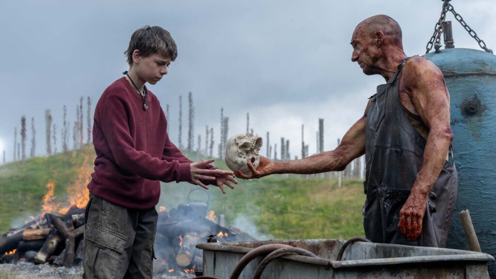 Alfie Williams as Spike and Ralph Fiennes as Dr Kelson in 28 Years Later, directed by Danny Boyle. Photo: Miya Mizuno. Copyright: 2025 CTMG, Inc. All Rights Reserved.