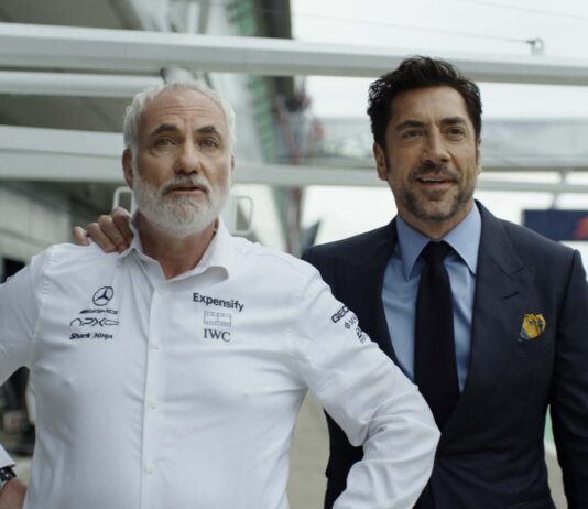 Kim Bodnia as Kaspar and Javier Bardem as Ruben Cervantes in F1: The Movie, directed by Joseph Kosinski. Copyright: Warner Bros. Entertainment Inc./Apple Original Films. All Rights Reserved.