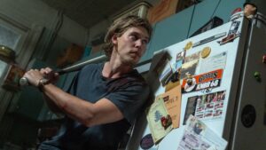 Austin Butler as Hank cautiously answers his front door in Caught Stealing, directed by Darren Aronofsky. Photo: Niko Tavernise. Copyright: CTMG, Inc. All Rights Reserved.