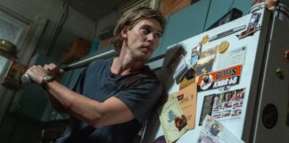 Austin Butler as Hank cautiously answers his front door in Caught Stealing, directed by Darren Aronofsky. Photo: Niko Tavernise. Copyright: CTMG, Inc. All Rights Reserved.