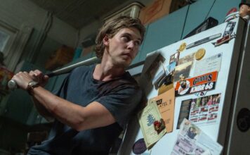 Austin Butler as Hank cautiously answers his front door in Caught Stealing, directed by Darren Aronofsky. Photo: Niko Tavernise. Copyright: CTMG, Inc. All Rights Reserved.