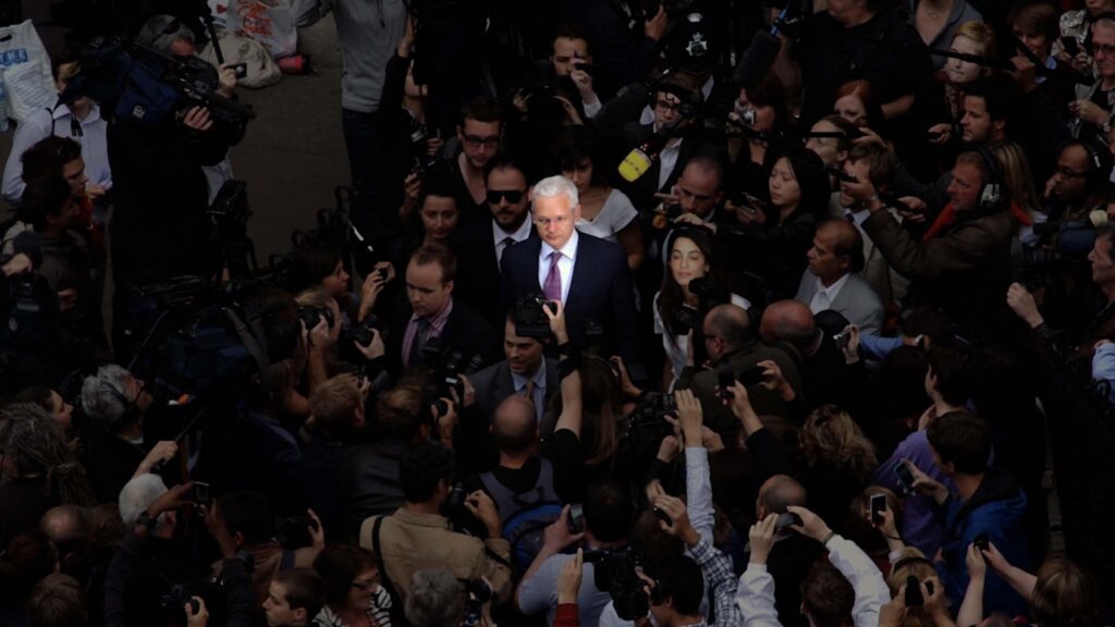 Julian Assange in a crowd in The Six Billion Dollar Man, directed by Eugene Jarecki. Copyright: Charlotte Street Films. All Rights Reserved.