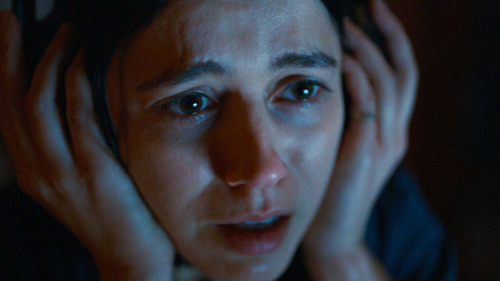 Nina Kiri as Evy in Undertone, directed by Ian Tuason. Copyright: A24. All Rights Reserved.