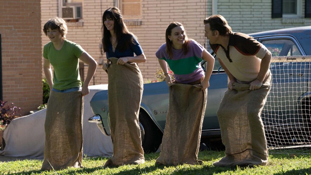 Christian Convery as Brian Platt, Anne Hathaway as Denise Platt, Maisy Stella as Audrey Platt and Ewan McGregor as Greg Platt in The End Of Oak Street, directed by David Robert Mitchell. Photo: Daniel McFadden. Copyright: Warner Bros. Entertainment Inc. All Rights Reserved.