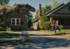 A dinosaur on the loose on Oak Street in The End Of Oak Street, directed by David Robert Mitchell. Photo: Daniel McFadden. Copyright: Warner Bros. Entertainment Inc. All Rights Reserved.