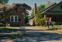 A dinosaur on the loose on Oak Street in The End Of Oak Street, directed by David Robert Mitchell. Photo: Daniel McFadden. Copyright: Warner Bros. Entertainment Inc. All Rights Reserved.