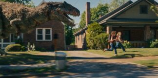 A dinosaur on the loose on Oak Street in The End Of Oak Street, directed by David Robert Mitchell. Photo: Daniel McFadden. Copyright: Warner Bros. Entertainment Inc. All Rights Reserved.