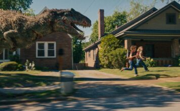 A dinosaur on the loose on Oak Street in The End Of Oak Street, directed by David Robert Mitchell. Photo: Daniel McFadden. Copyright: Warner Bros. Entertainment Inc. All Rights Reserved.