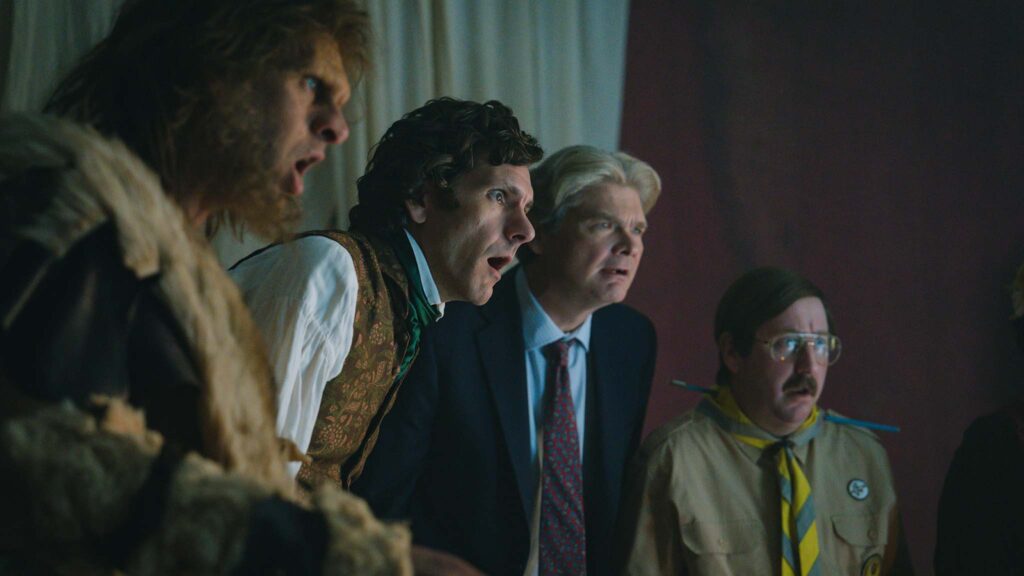 Laurence Rickard as caveman Robin, Mathew Baynton as Thomas Thorne, Simon Farnaby as Julian Fawcett and Jim Howick as Pat Butcher in Ghosts: The Possession Of Button House, directed by Simon Hynd. Copyright: Mandozzi Photography/Guido Mandozzi. All Rights Reserved.